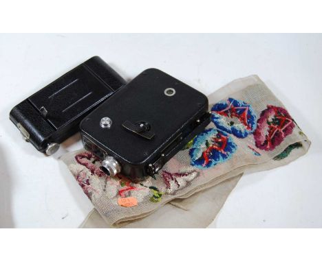 A cased bellows camera; a French Kodak Anastigmatic camera; and a woolwork sash (3)