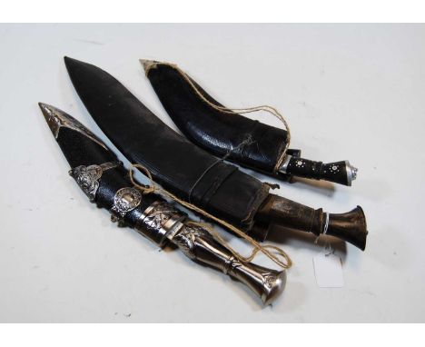 An Eastern kukri knife, with scabbard, 45cm; together with one other smaller; and a modern reproductiom example (3)