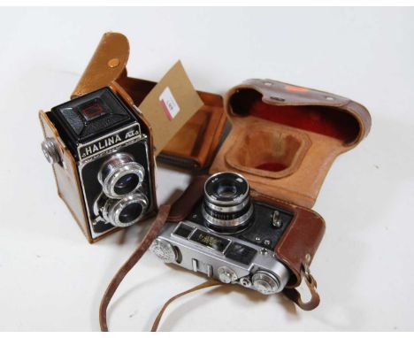 A leather cased Halina medium format camera; together with a 35mm SLR camera (2)