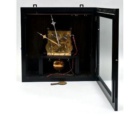 Wanduhr Schwarz lackiertes Kastengehäuse in quadratischer Form mit Front- und Seitenverglasung. Zifferblattfreie Uhr mit Fede