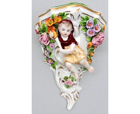 Porzellan-Wandkonsole, Sitzendorf (Thüringen), Ende 19./ 20. Jh. Reiche Blütenauflagen, plastischer Figurenschmuck: ein Putto