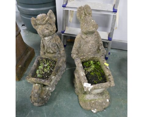 Two composite garden ornaments, andromorphic animals pushing wheelbarrows