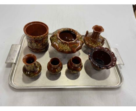 Linthorpe Pottery: seven pieces of floral decoration on brown ground.