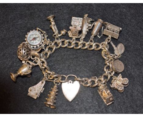 A silver charm bracelet set with fourteen charms, including caravan, piano, compass, telephone, etc., padlock clasp, 93g gros