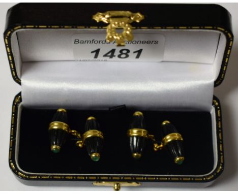 A pair of onyx and emerald cufflinks, ridged onyx tapering barrels, each end inset with a round cabochon emerald, gilt metal 