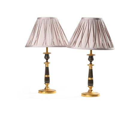 A PAIR OF BRONZE AND GILT CANDLESTICKS CIRCA 1830 later fitted for electricity 27 cm tall to top of candlestick, 51 cm tall i