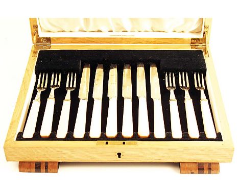 AN ART DECO CASED SET OF SIX PAIRS OF FRUIT/DESSERT KNIVES & FORKS with simulated ivory handles, maker's mark "GH", Sheffield