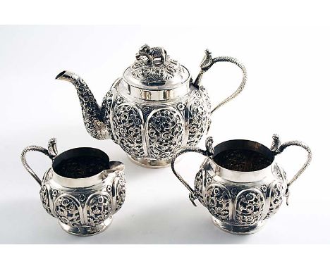 A LATE 19TH / EARLY 20TH CENTURY INDIAN THREE-PIECE TEA SET with lobed and profusely decorated bodies &amp; cobra handles, th