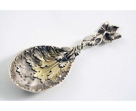 A VICTORIAN PARCELGILT CADDY SPOON with a leafy bowl & stem, the back of the terminal initialled "AAC", by George Adams, Lond