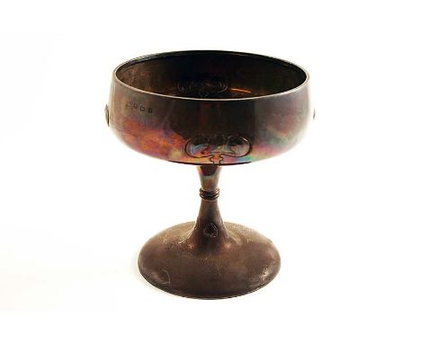 AN EDWARDIAN ART NOUVEAU DISH on a waisted pedestal foot with a shallow circular bowl, decorated with four embossed stylised 
