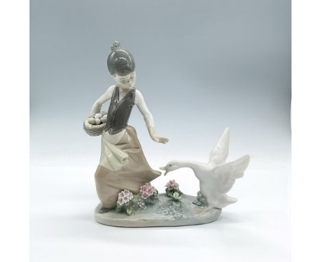 Lovely young girl with her basket of eggs shooing a goose. Pretty flowers adorn the ground. Glossy finish. Lladro backstamp. 
