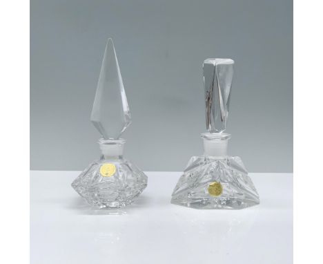 Two crystal perfume bottles, one featuring an octagonal design with a sleek spearhead-shaped stopper, and the other boasting 