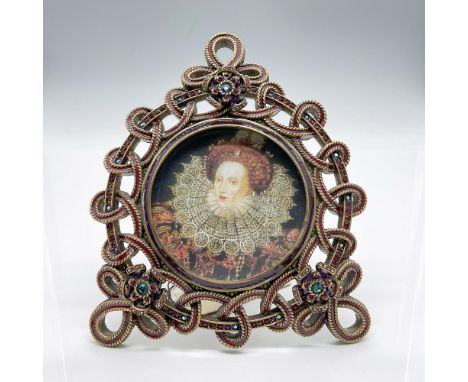 Beautiful gold tone rope edge metal with burgundy enamel inset form the design for this round frame. Three flowers adorn the 