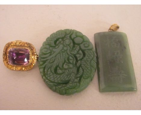 Two early 20th century carved jade pendants together with a Georgian amethyst brooch