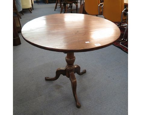 A George III mahogany tilt top tea table having a turned column support on splayed legs