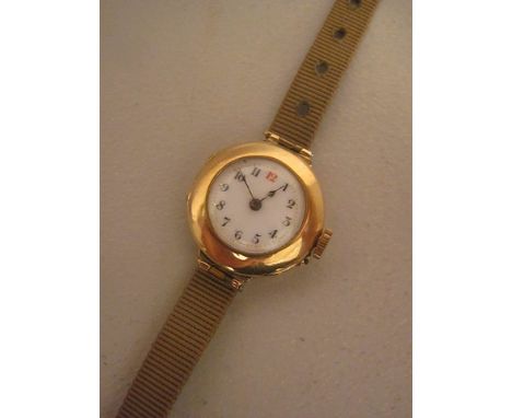 An Edwardian 15ct gold ladies' wristwatch with a white enamel dial and 15-jewel movement on a silk strap
