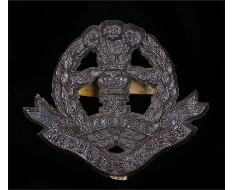World War Two plastic economy cap badge to the Middlesex Regiment, in chocolate brown, two blades to the reverse, marked F & 