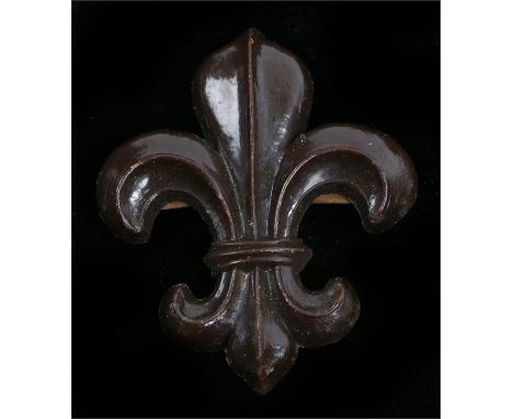 World War Two plastic economy cap badge to the Manchester Regiment, in chocolate brown, two blades to the reverse, K&K 2253