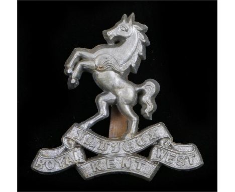 World War Two plastic economy cap badge to the Queens Own Royal West Kent Regiment, in silver grey, two blades to the reverse