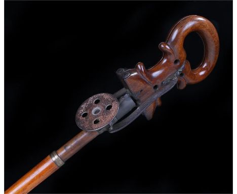 Unusual 19th Century shooting stick, the carved mahogany hinged, arched seat/handle with a roundel to screw into the spiked b