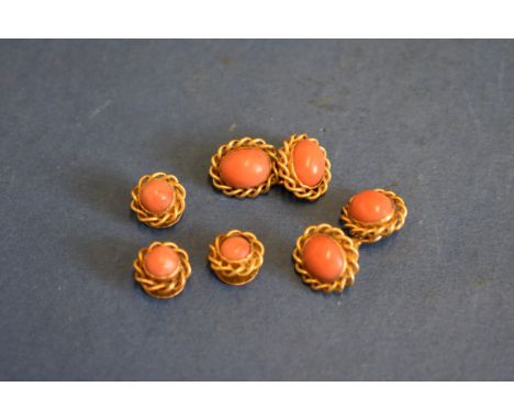 A pair of unmarked gold cufflinks set cabachon coral and three matching studs. 