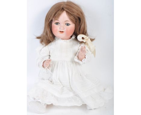 An antique German made Armand Marseille bisque headed doll. The doll having blue flirty eyes, finely painted eyelashes and br