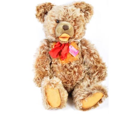 An original German Steiff made soft toy teddy bear. The bear having golden fine curl mohair, fully jointed limbs, felt padded