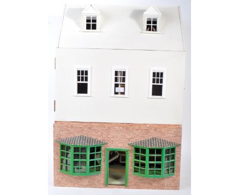 A charming vintage Victorian style doll's house - in the manner of a small town house with shop beneath. Comprising of three 