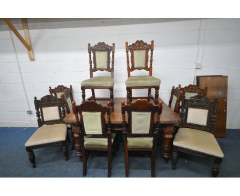 AN EDWARDIAN OAK WIND OUT DINING TABLE, with canted corners, turned and fluted legs, on ceramic castors, foliate carving to e