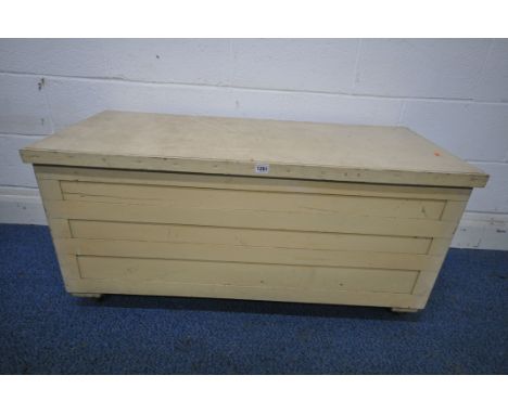A CREAM PAINTED WOODEN TOOL CHEST, with a hinged lid, on castors, width 113cm x depth 49cm x height 54cm (condition report: s