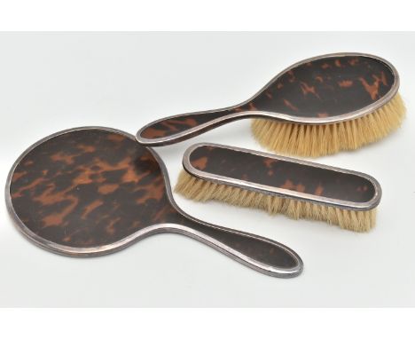 A SILVER AND TORTOISESHELL THREE PIECE VANITY SET, comprising of a hair brush, clothes brush and a hand held mirror, each pie