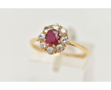 A YELLOW METAL RUBY AND DIAMOND CLUSTER RING, of a circular form, set with a central circular cut ruby, in a surround of eigh