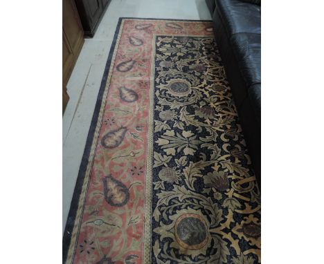 A modern carpet square in patterned deep blue with pink patterned border 