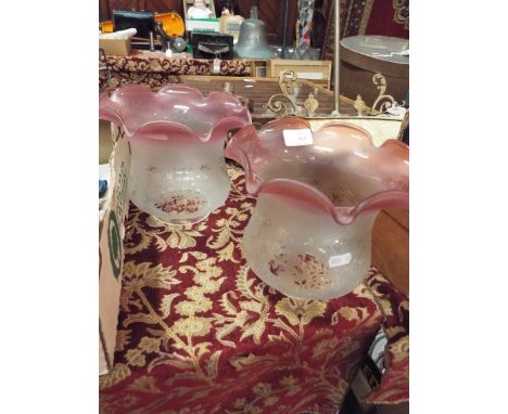 An Edwardian brass light fitting with two pink etched glass shades