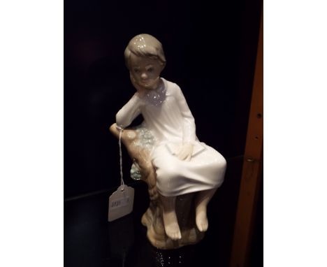 A Lladro figurine of a young girl sitting on a tree stump