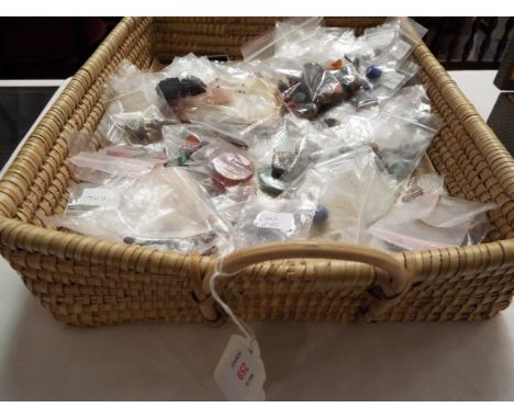 A wicker basket containing a large selection of jewellery stones, agates etc to include tigers eye, coral, cats eyes, cabocho