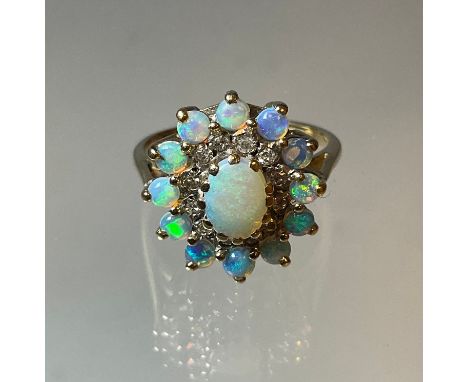 An opal and diamond cluster ring, central oval opal cabochon within two collars of twelve round brilliant cut diamonds and tw