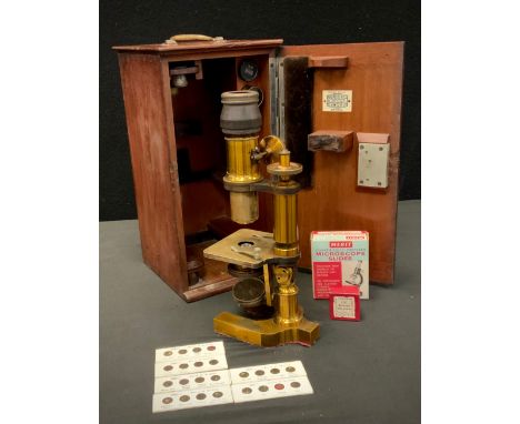 A 19th century brass monocular microscope, assorted optics and lenses in Bausch &amp; Lomb lenses, World of Science slides et