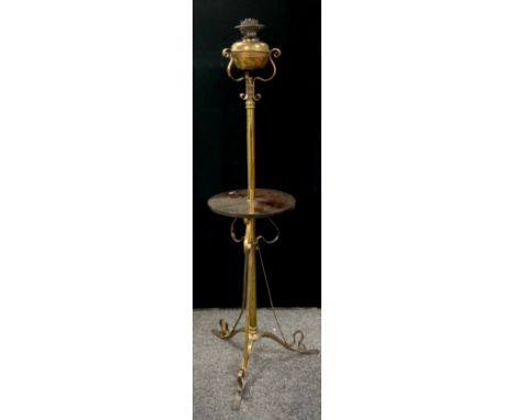 An early 20th century telescopic floor standing oil lamp stand, gilt metal scroll tri-pod feet and oil burner, mahogany woode