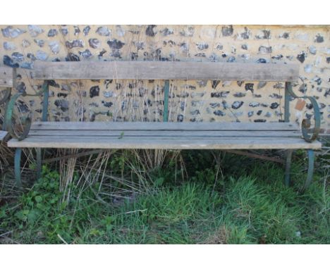 A wrought iron scrolled arm garden bench with slatted seats, 72" wide