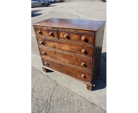 An early 19th century elm and pine chest of two short and three long graduated drawers, on bracket supports, 43" wide x 19 1/