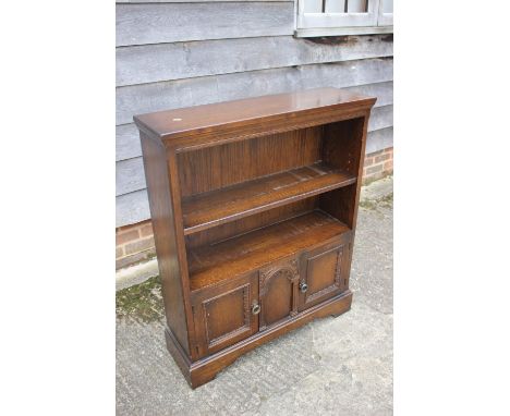 An oak open bookcase, fitted open shelves over cupboards, on bracket feet, 33" wide x 40" high, a&nbsp;hardwood magazine stan