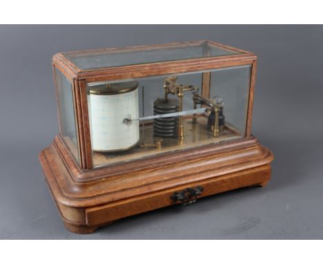 A brass barograph, in oak and bevelled glass display case