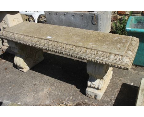 A rectangular cast stone garden bench with egg and dart border, on scrolled twin pedestal supports, 45" wide