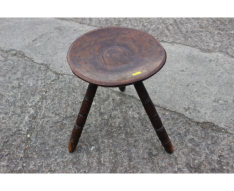 An antique fruitwood circular dish top milking stool, on turned supports, 12" dia x 13" high Condition report: the top has po