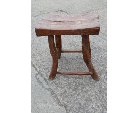 A mid 19th century rustic oak elm and walnut stool with dished top 