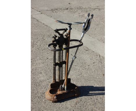 A cast iron stick stand, 29 1/2" high, and two shooting sticks
