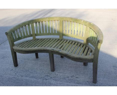 A  Lindsey plantation teak slatted kidney shaped garden bench, 61" wideThe height of the bench is 33 1/2"
