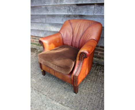 A leather tub chair with chocolate velour loose cushion, on square taper supports