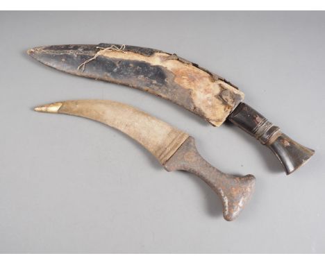 A khanjar type dagger with white metal and brass inlaid grip and material sheath, and a kukri with leather sheath (both ruste